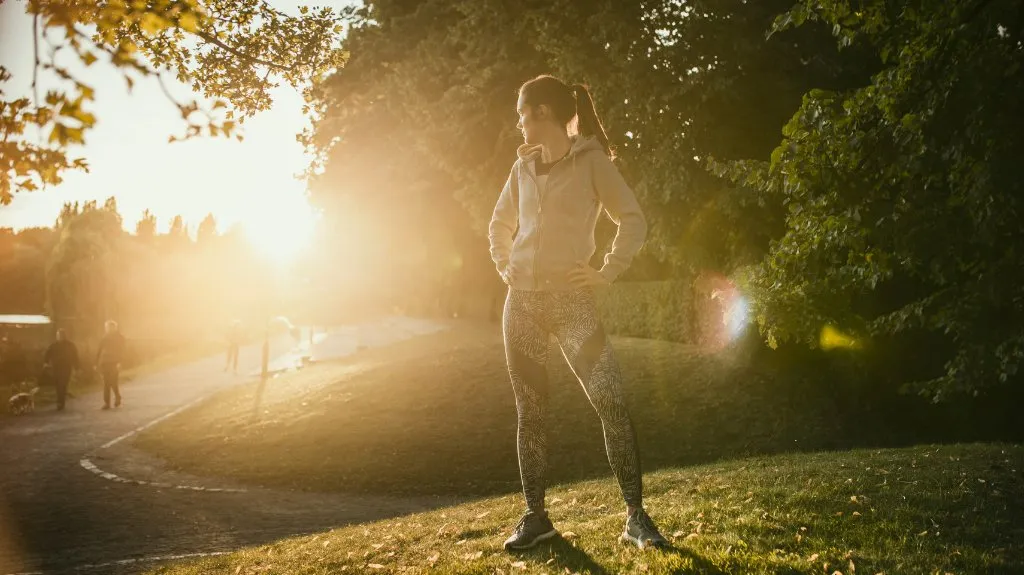 Frau beim Joggen im Park bei Sonnenaufgang als Symbol dafür, warum Bewegung wichtig für Gesundheit und Wohlbefinden ist