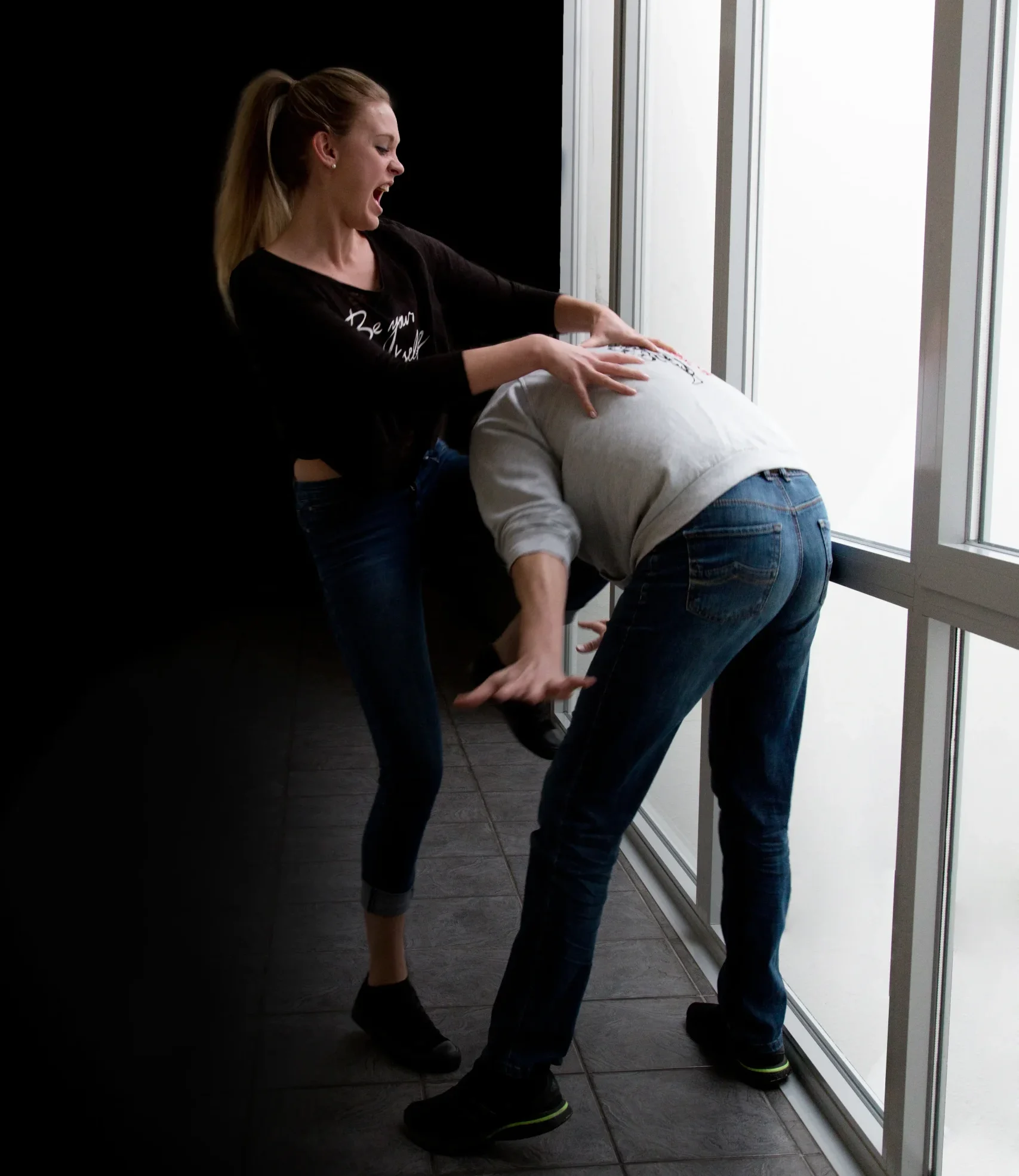 Frau übt eine Selbstverteidigungstechnik mit einem Trainingspartner in Alltagskleidung